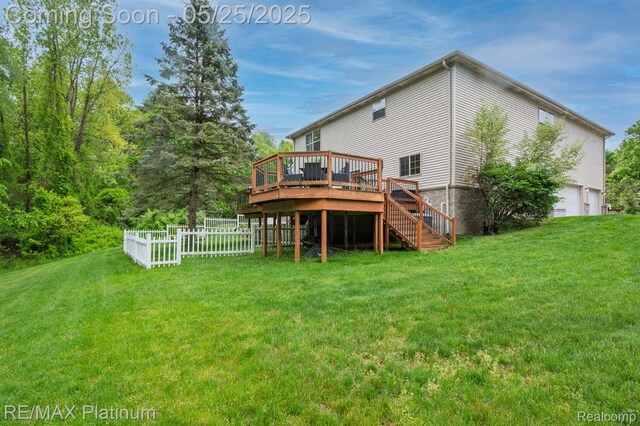 2038 Pine Bluffs Ct, Highland, MI 48357 - back of house with a deck, a lawn, a garage, and stairs