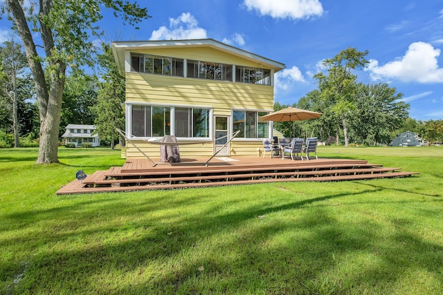 back of property featuring a wooden deck and a yard