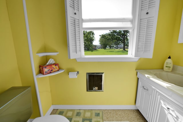 bathroom featuring baseboards, toilet, vanity, and heating unit