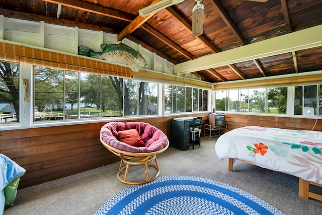 carpeted bedroom with wood walls and wood ceiling