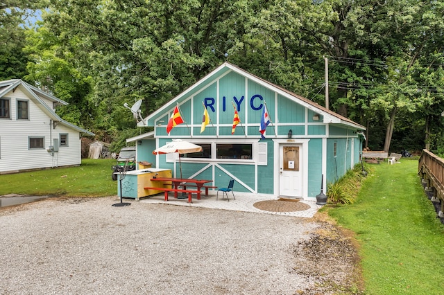 view of front of home featuring a front yard, concrete block siding, and an outbuilding