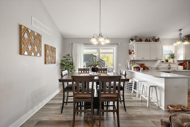 3582 Pratt Dr, Lapeer, MI 48446 - dining space featuring a chandelier, dark wood-style floors, and baseboards
