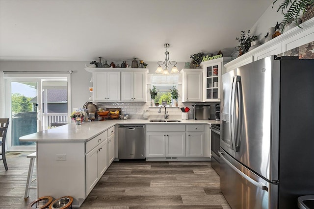 3582 Pratt Dr, Lapeer, MI 48446 - kitchen featuring appliances with stainless steel finishes, a peninsula, a sink, dark wood-type flooring, and white cabinetry