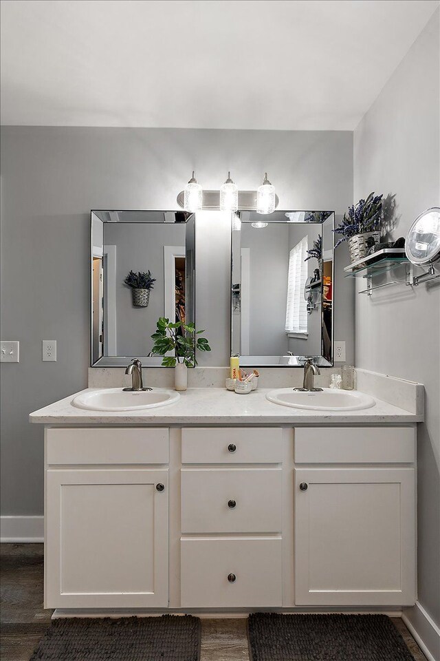 3582 Pratt Dr, Lapeer, MI 48446 - bathroom featuring wood finished floors, double vanity, and baseboards