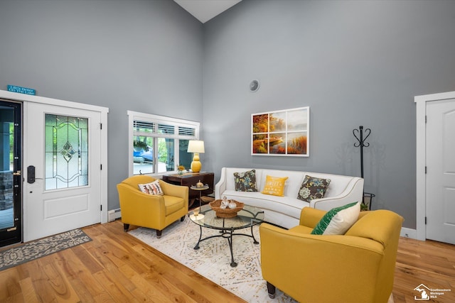 2307 Tecumseh Dr, Brooklyn, MI 49230 - living room featuring high vaulted ceiling, wood finished floors, a baseboard heating unit, and baseboards