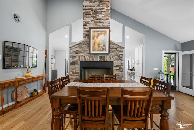 2307 Tecumseh Dr, Brooklyn, MI 49230 - dining room featuring light wood-type flooring, a fireplace, and high vaulted ceiling