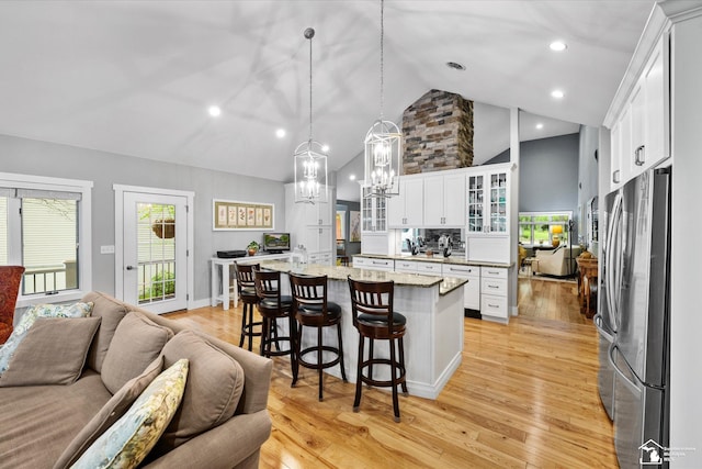 2307 Tecumseh Dr, Brooklyn, MI 49230 - kitchen with freestanding refrigerator, open floor plan, a chandelier, white cabinetry, and a kitchen bar