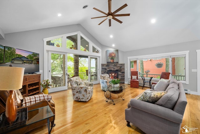2307 Tecumseh Dr, Brooklyn, MI 49230 - living room with ceiling fan, high vaulted ceiling, a stone fireplace, plenty of natural light, and light wood-type flooring