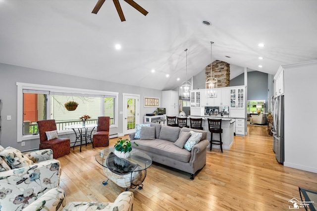 2307 Tecumseh Dr, Brooklyn, MI 49230 - living area featuring a chandelier, a baseboard heating unit, a ceiling fan, light wood finished floors, and high vaulted ceiling