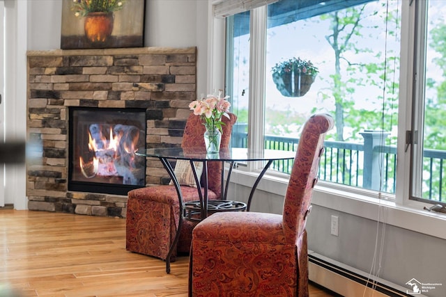 2307 Tecumseh Dr, Brooklyn, MI 49230 - dining area featuring baseboard heating, wood finished floors, and a stone fireplace
