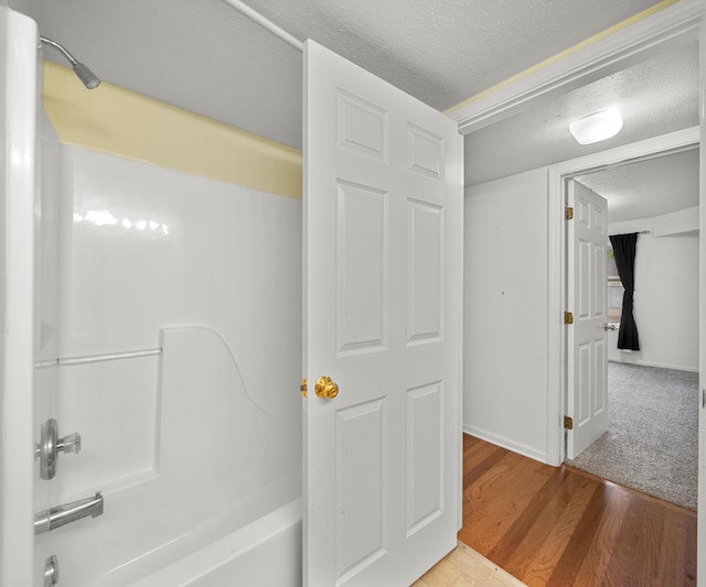 1379 Millbrook Trl, Ann Arbor, MI 48108 - bathroom featuring wood finished floors, a textured ceiling, bathtub / shower combination, and baseboards