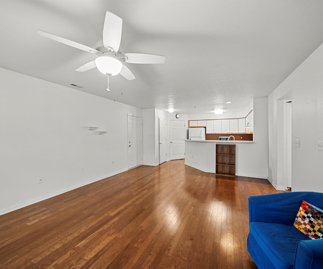 1379 Millbrook Trl, Ann Arbor, MI 48108 - unfurnished living room featuring dark wood-style flooring, a ceiling fan, and baseboards