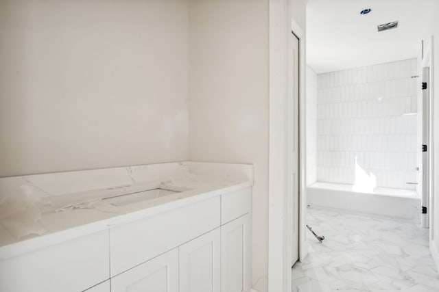 45070 Twin River Dr, Macomb, MI 48044 - bathroom featuring marble look tile flooring, a tub to relax in, and vanity