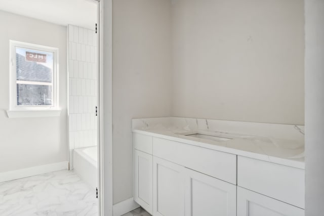 45070 Twin River Dr, Macomb, MI 48044 - full bathroom featuring marble look tiles, a tub, and baseboards