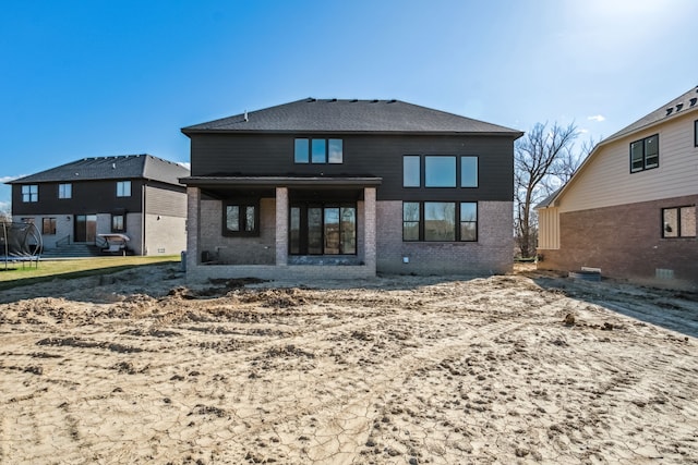 45070 Twin River Dr, Macomb, MI 48044 - rear view of property with brick siding and a trampoline
