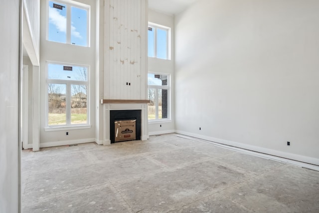 45070 Twin River Dr, Macomb, MI 48044 - unfurnished living room with a towering ceiling, healthy amount of natural light, baseboards, and a large fireplace