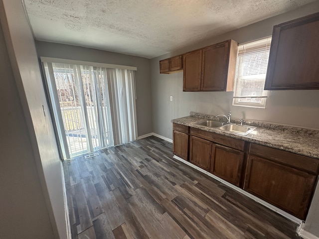 15748 Freeland St, Detroit, MI 48227 - kitchen with a sink, dark wood finished floors, a textured ceiling, baseboards, and brown cabinets