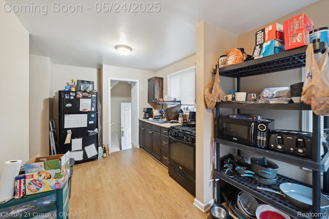 1216 E George Ave, Hazel Park, MI 48030 - kitchen with black appliances, light wood-style floors, and dark brown cabinetry
