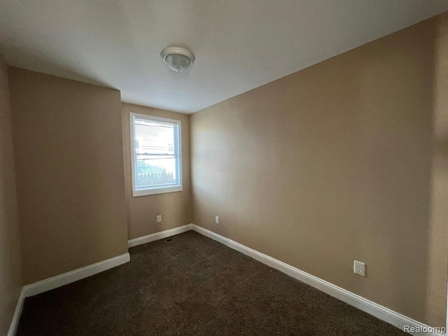 5671 Otis St, Detroit, MI 48210 - unfurnished room featuring dark carpet and baseboards