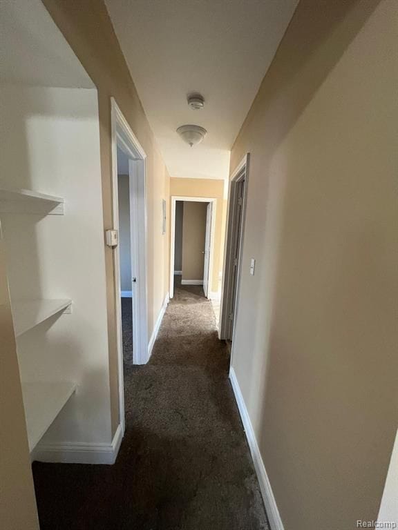 5671 Otis St, Detroit, MI 48210 - corridor featuring dark carpet and baseboards