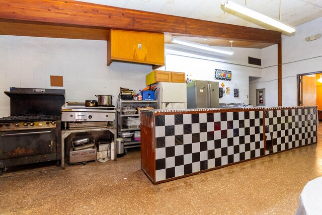 20800 Lefever Ave, Warren, MI 48091 - kitchen featuring concrete block wall, freestanding refrigerator, and gas range oven