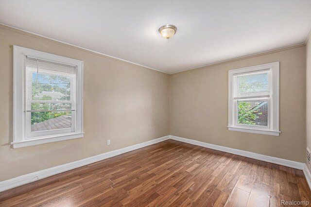 259 Navajo Ave, Pontiac, MI 48341 - empty room featuring plenty of natural light, wood finished floors, baseboards, and ornamental molding