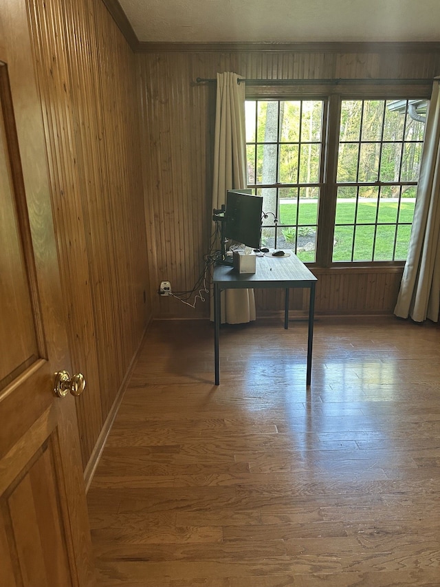 home office with wooden walls and wood finished floors