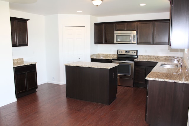 58192 Kincaid St, New Haven, MI 48048 - kitchen featuring appliances with stainless steel finishes, a sink, dark brown cabinetry, light stone countertops, and recessed lighting