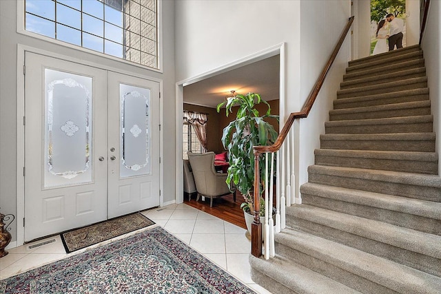 58 Ingram Dr, Troy, MI 48098 - entryway featuring stairs, light tile patterned floors, french doors, and a high ceiling