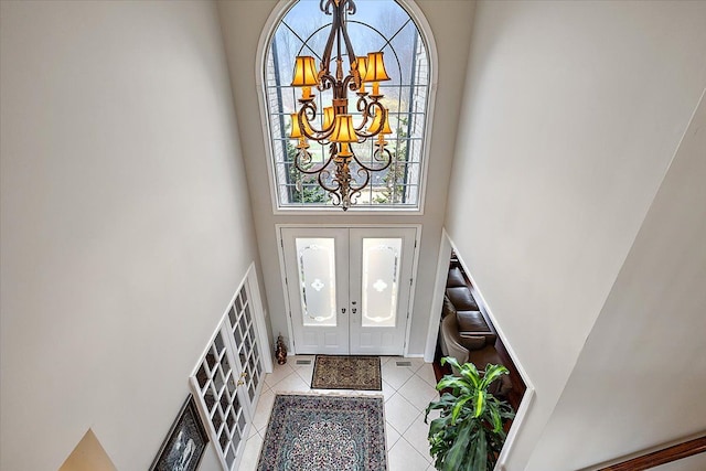 58 Ingram Dr, Troy, MI 48098 - foyer entrance featuring a high ceiling, a chandelier, french doors, light tile patterned floors, and baseboards