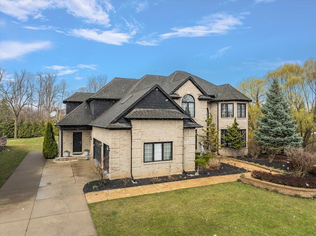 58 Ingram Dr, Troy, MI 48098 - french country home with concrete driveway, a front lawn, a garage, and brick siding