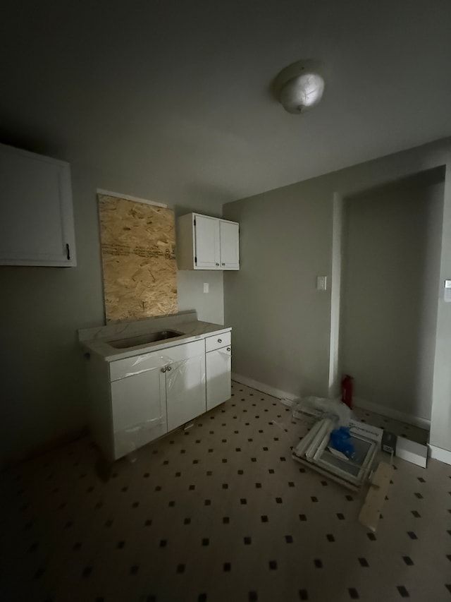15904 Muirland St, Detroit, MI 48238 - kitchen with a sink, white cabinetry, baseboards, and light countertops