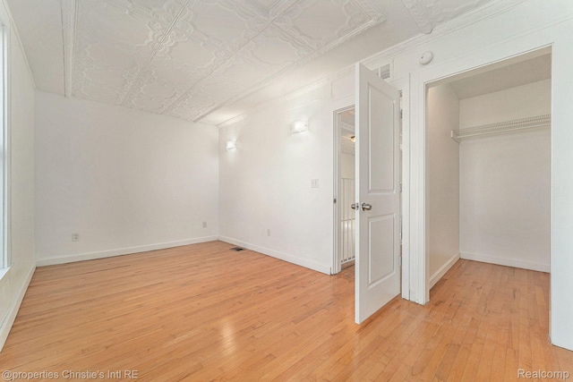 8820 Joseph Campau St Unit 2, Hamtramck, MI 48212 - unfurnished bedroom featuring light wood finished floors, baseboards, and an ornate ceiling