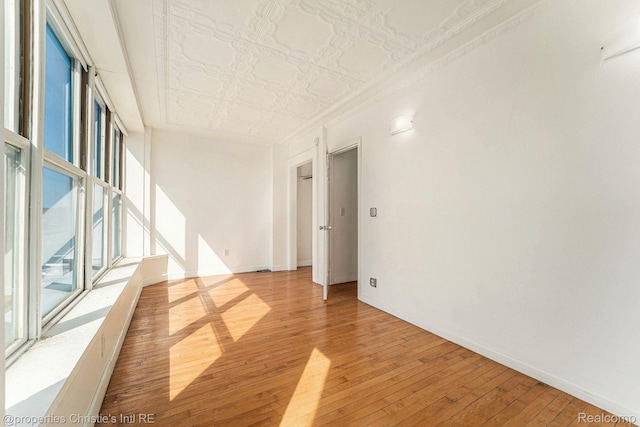 8820 Joseph Campau St Unit 2, Hamtramck, MI 48212 - spare room featuring light wood-style floors, plenty of natural light, an ornate ceiling, and baseboards