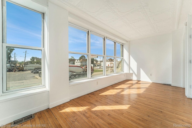 8820 Joseph Campau St Unit 2, Hamtramck, MI 48212 - spare room with baseboards, wood-type flooring, and an ornate ceiling
