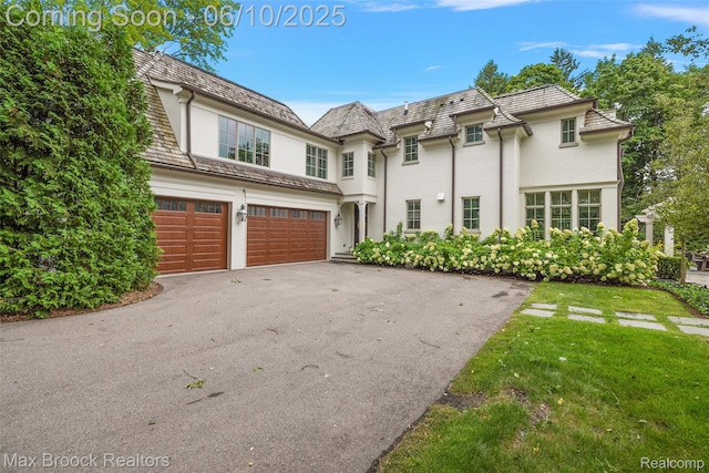 1475 Tottenham Rd, Bloomfield Hills, MI 48301 - view of front of home with driveway, an attached garage, stucco siding, and a front lawn