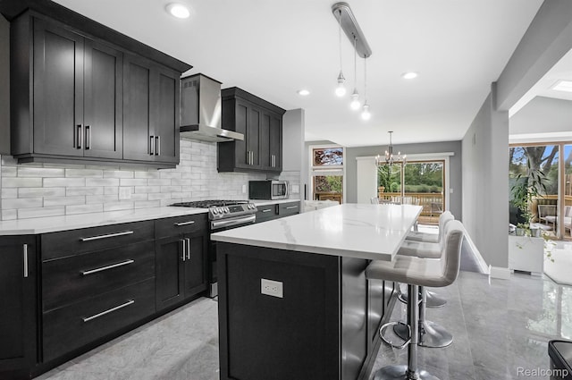 6655 Mountain Dr, Troy, MI 48098 - kitchen with appliances with stainless steel finishes, wall chimney range hood, dark cabinetry, tasteful backsplash, and a kitchen island