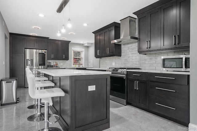 6655 Mountain Dr, Troy, MI 48098 - kitchen with appliances with stainless steel finishes, wall chimney range hood, a kitchen island, decorative backsplash, and a breakfast bar area