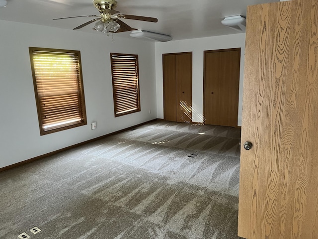 3048 Vineland Ave, Burton, MI 48519 - unfurnished bedroom featuring carpet flooring, two closets, ceiling fan, and baseboards