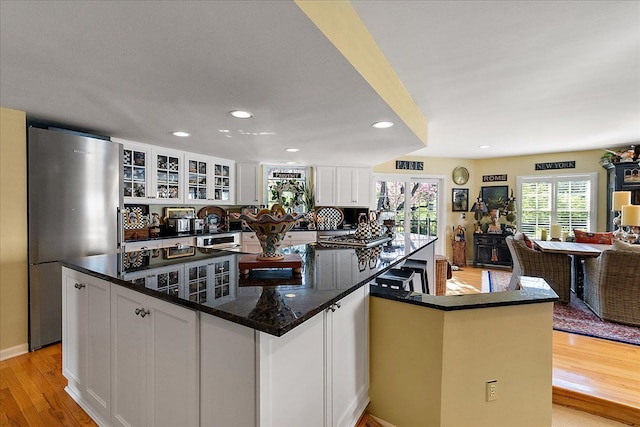 1301 Fairway Dr, Birmingham, MI 48009 - kitchen with freestanding refrigerator, white cabinetry, light wood-style floors, open floor plan, and glass insert cabinets