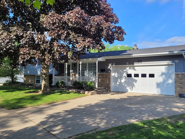 view of front of house featuring brick siding, driveway, an attached garage, and a front lawn