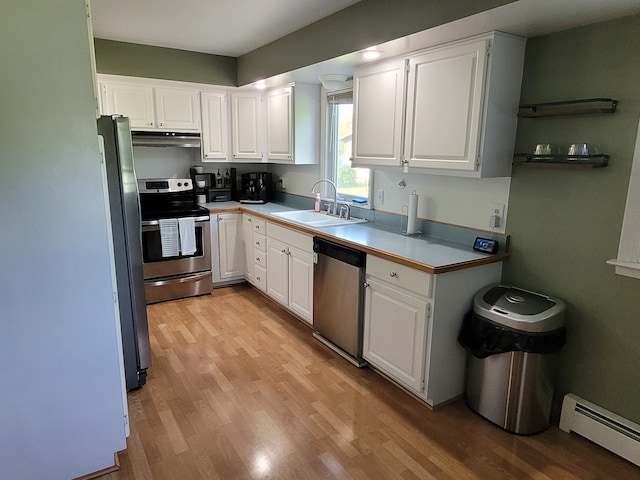 kitchen featuring stainless steel appliances, a baseboard heating unit, a sink, and light wood finished floors