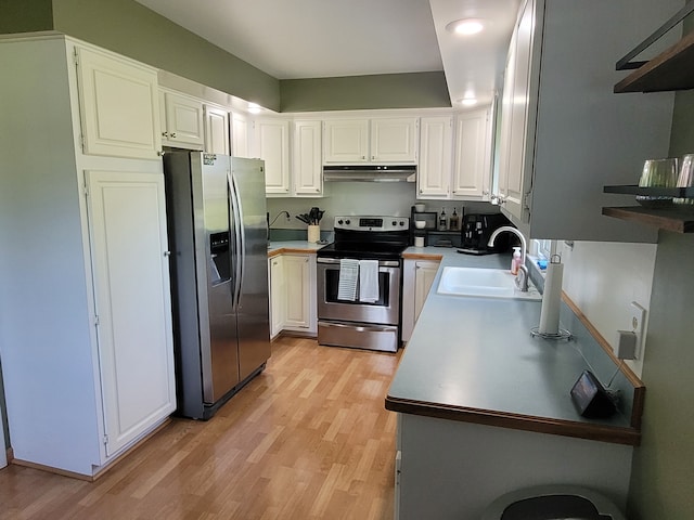 kitchen with stainless steel appliances, a sink, under cabinet range hood, and light wood-style floors