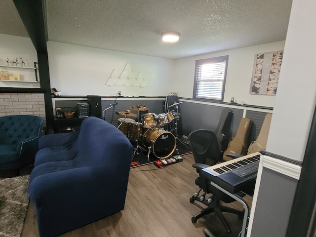game room with wood finished floors and a textured ceiling