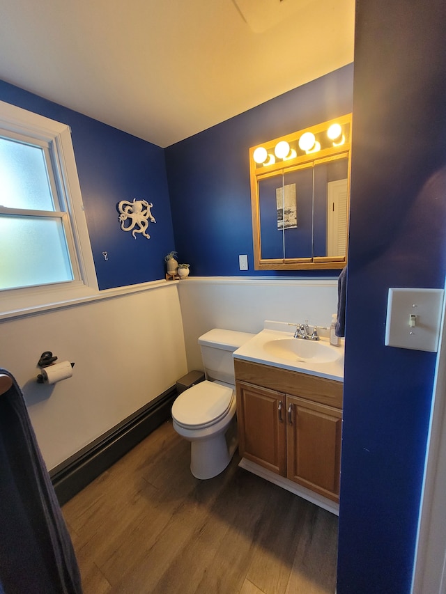 half bath featuring wood finished floors, toilet, and vanity