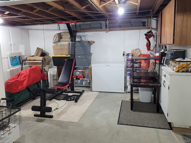 unfinished below grade area with refrigerator and concrete block wall