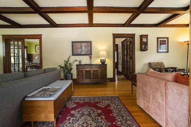 living area with coffered ceiling, wood finished floors, beamed ceiling, and french doors