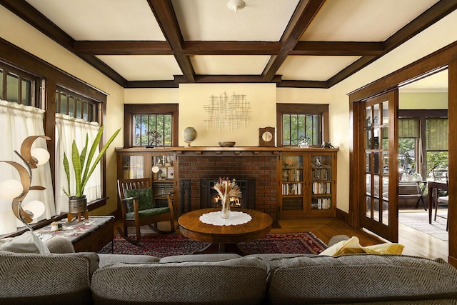 living room featuring coffered ceiling, a brick fireplace, wood finished floors, beam ceiling, and baseboards