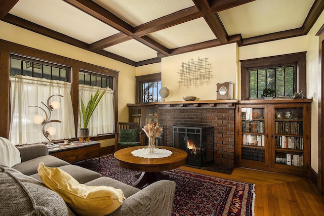 living room with healthy amount of natural light, coffered ceiling, a fireplace, beam ceiling, and baseboards