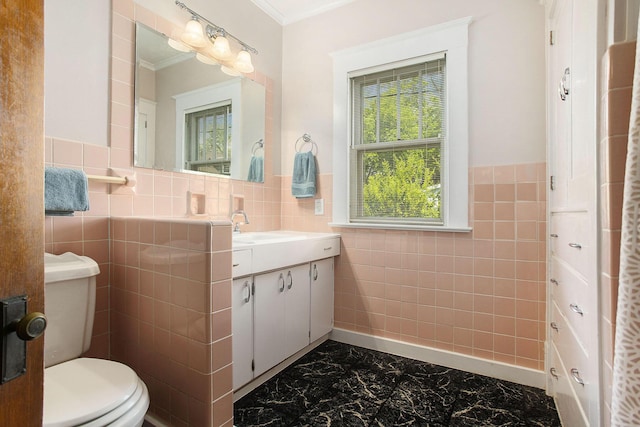 bathroom featuring tile walls, marble finish flooring, toilet, vanity, and ornamental molding